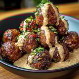A bowl of meatballs with a dipping sauce.