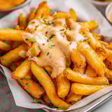 A plate of fries with cheese on top.