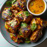 A plate of meat with a bowl of sauce.