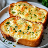 Two pieces of cheese toast on a white plate.