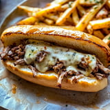 Authentic Philly cheesesteak sandwich with tender beef, melted cheese, and sautéed onions.