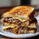 Juicy classic patty melt with crispy rye bread, melted cheese, and caramelized onions.