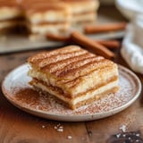 Buttery cinnamon churro cheesecake bars with a smooth, velvety center.